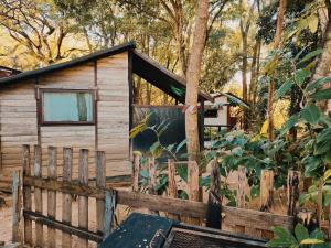 a cabin in the woods behind a fence at Hazyview Adventure Backpackers in Hazyview