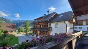 a house with flowers on a wooden fence at Schmiedlehnerhof in Birnberg
