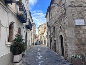 an alley with buildings and a car driving down it at Pasitea in Potenza