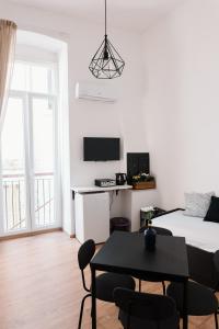 a white room with a bed and a table with chairs at Borgo Sant' Angelo Exclusive House in Conversano