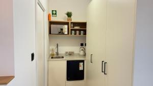 a kitchen with white cabinets and a sink at River Breeze Douro - Casa Touriga in Marmelal