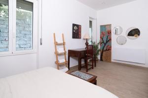 a bedroom with a bed and a desk and a window at Domo Cadò in Berchidda +38 photos