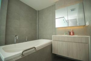 a bathroom with a tub and a sink and a mirror at 85 SOHO Premium Residences in Yangon +12 photos