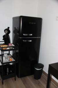 a black refrigerator in a kitchen with a black shelf at Maison d'hote villa monique in Cuges-les-Pins