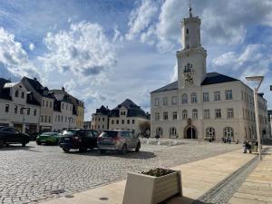 a large white building with a clock tower on a street at KuschLnest Schneeberg in Schneeberg