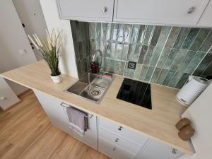 a kitchen with a sink and a counter top at DEUX rooms in Liepāja