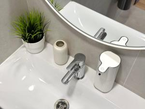 a bathroom sink with a faucet and a mirror at DEUX rooms in Liepāja