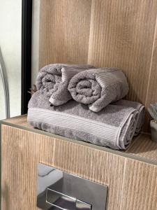 a stack of towels on a counter with a mirror at DEUX rooms in Liepāja