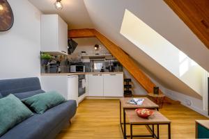 a living room with a couch and a kitchen at Le 38-Appart'Hôtel-GregIMMO in Montbéliard