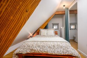 a bedroom with a bed in the attic at Le 38-Appart'Hôtel-GregIMMO in Montbéliard