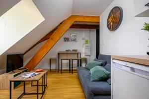 a living room with a couch and a table at Le 38-Appart'Hôtel-GregIMMO in Montbéliard