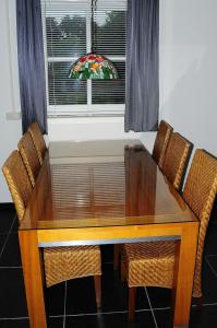 een eettafel met stoelen en een raam bij Herkenhoek 3 bedroom apartement in Heeswijk-Dinther