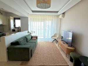 a living room with a green couch and a television at Sophia Luxury Residence in Mamaia