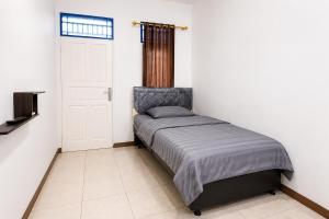 a small bedroom with a bed and a door at Rays Residence in Jakarta