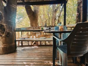 a table and a chair on a wooden deck at Hazyview Adventure Backpackers in Hazyview