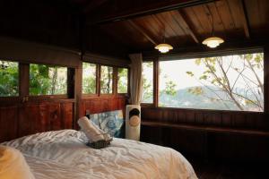 a bedroom with a bed in a room with windows at SIA Home - Dalat Haus in Ấp Ða Lợi