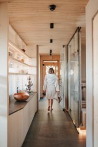 a woman walking down a hallway in a bathroom at Eco Bnb & Apartments Bründlerhof in Marlengo