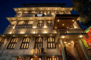 a tall building with lights on it at night at Palette by CheckIn Heritage Scindia Ghat in Varanasi