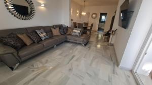 a living room with a couch and a table at 240 Front line beach La Cala in La Cala de Mijas