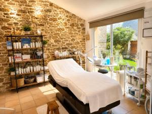 a hospital room with a bed and a brick wall at Aux Matins du Bonheur in Surzur