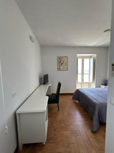 a bedroom with a bed and a desk and a chair at Kento Resort Hotel in Centuripe +49 photos