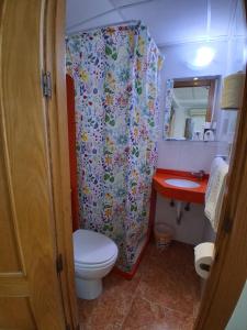a bathroom with a toilet and a shower curtain at Pension Segura in Murcia +54 photos