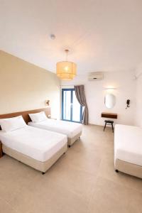 a hotel room with two beds and a table at Marcos Beach in Mylopotas