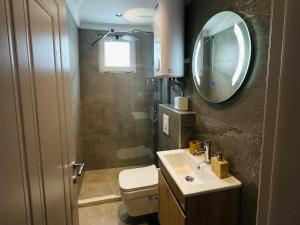 a bathroom with a toilet and a sink and a mirror at Casa Meellas in Donji Štoj