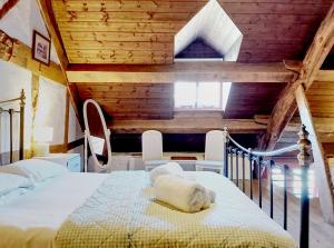 a bedroom with a bed in a room with wooden ceilings at Longhouse - Y Beudy in Rhayader