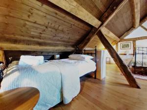 two beds in a attic room with wooden ceilings at Longhouse - Y Beudy in Rhayader