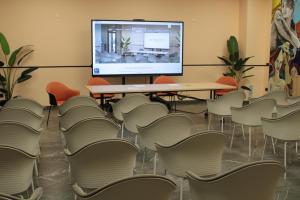 a room with a table and chairs and a screen at Orizzonte MHotel in Andria