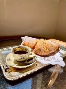 a tray with a cup of coffee and some bread at Corte Pozzol in Rivoli Veronese