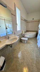 a bathroom with two sinks and a tub and a toilet at Locanda dei Sapori in Marozzo