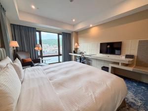 a hotel room with a large bed and a television at Grand Victoria Hotel in Taipei