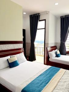 a bedroom with two beds and a large window at Yen Phu Hotel Tuy Hòa in Tuy Hoa