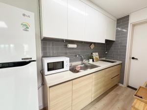 a kitchen with a sink and a microwave at 깨비하우스202 in Wŏlsan