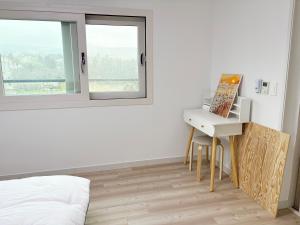 a bedroom with a desk and a bed with a window at 깨비하우스202 in Wŏlsan