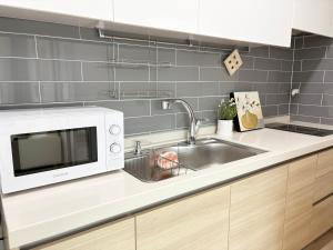 a kitchen with a sink and a microwave at 깨비하우스202 in Wŏlsan