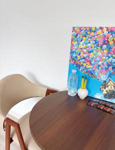 a table with a bottle of water and a painting on it at 깨비하우스202 in Wŏlsan