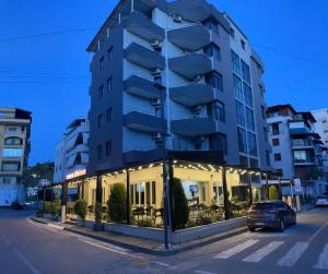 a car parked in front of a tall building at Hotel Riviera in Durrës