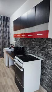 a kitchen with red and black cabinets and a counter at Blue House 2 in Warsaw