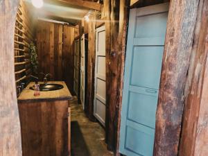 a bathroom with a sink and a blue door at Hazyview Adventure Backpackers in Hazyview