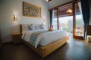 a bedroom with a large bed and a large window at Ardinia Villa Ubud Private Pool in Ubud +66 photos