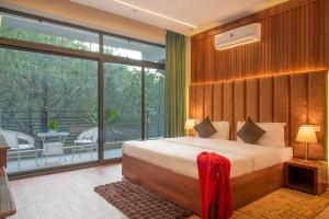 a bedroom with a large bed and a balcony at The Royal Apartments Manor I Roof Top Restaurant I Self Cooking Available I Lift I 7o1827o7o3 in Kasauli