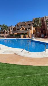 a large swimming pool in front of some buildings at Playa y Geoda, escapada perfecta in Pilar de Jaravía