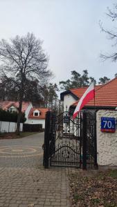 a black gate with a sign on it next to a house at Blue House 2 in Warsaw
