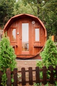 a small wooden building in a yard next to a fence at Planinska kuća Vista in Mrkopalj +5 photos
