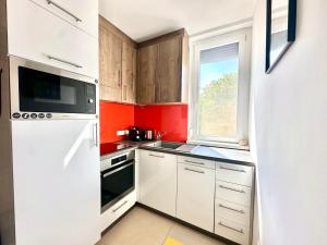 a small kitchen with white cabinets and a window at Casa Viola in Balatonfüred