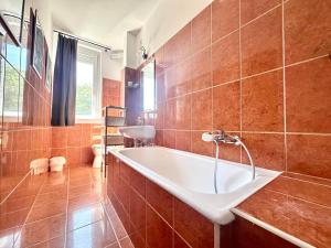 a bathroom with a tub and a sink at Casa Viola in Balatonfüred