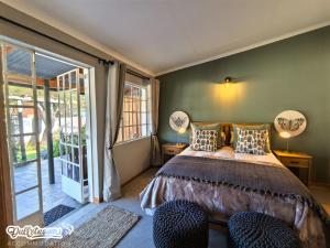a bedroom with a bed with two lamps and a sliding glass door at Suikerbosch Room 1 and Room 2 in Dullstroom